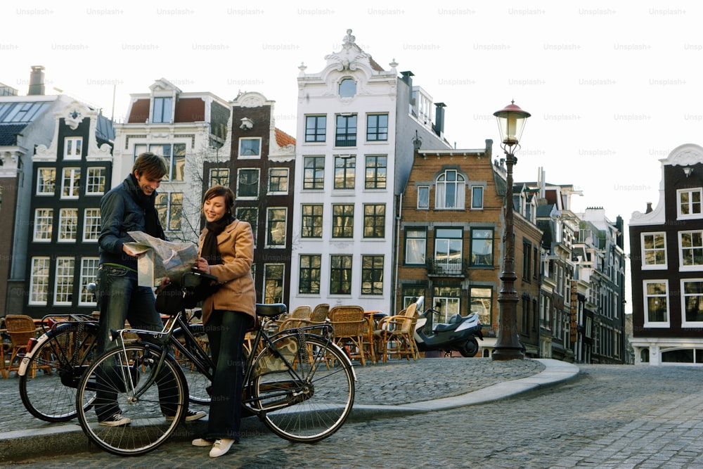 a man and woman standing next to each other on bicycles