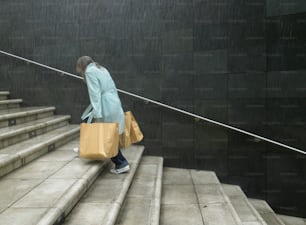 a woman walking down a set of stairs carrying shopping bags