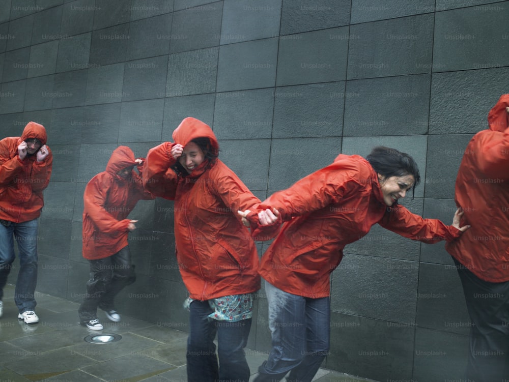 Un grupo de personas con chaquetas rojas de pie junto a una pared