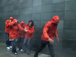 Un gruppo di persone in giacca rossa in piedi accanto a un muro