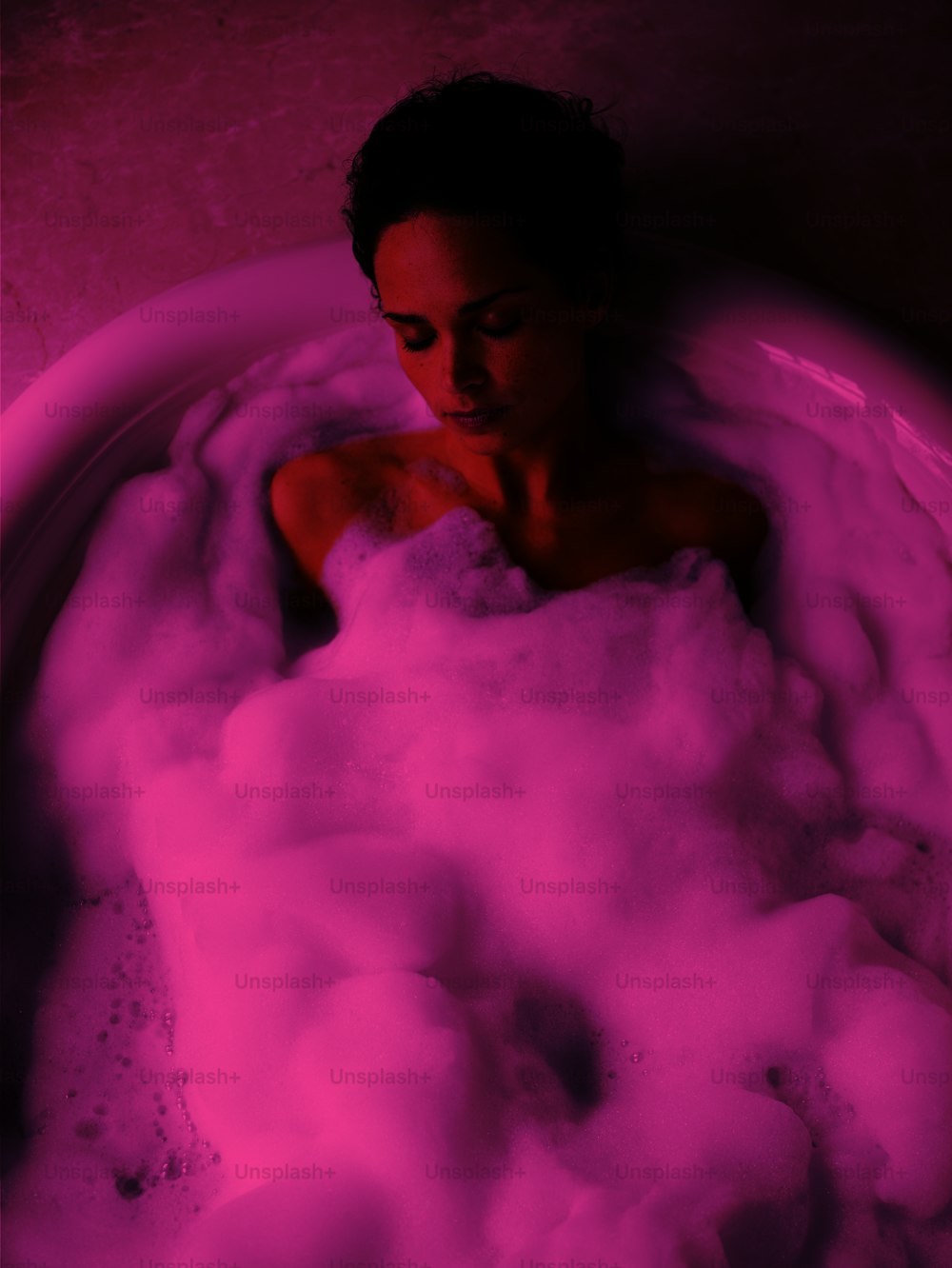 a woman sitting in a bathtub filled with foam