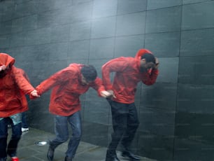 a group of people in red jackets standing next to a wall