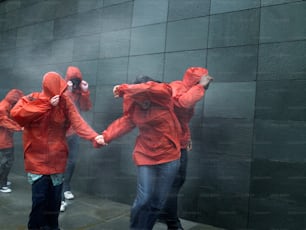 a group of people in red raincoats holding hands
