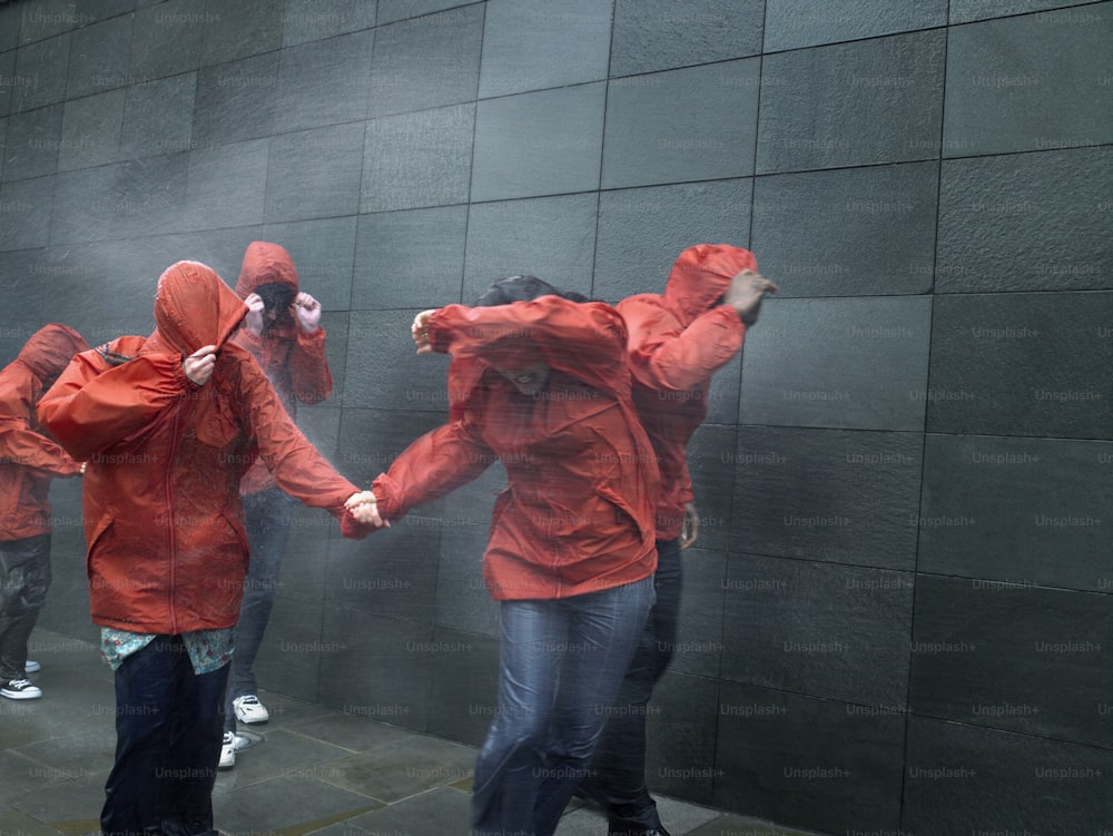 a group of people in red raincoats holding hands