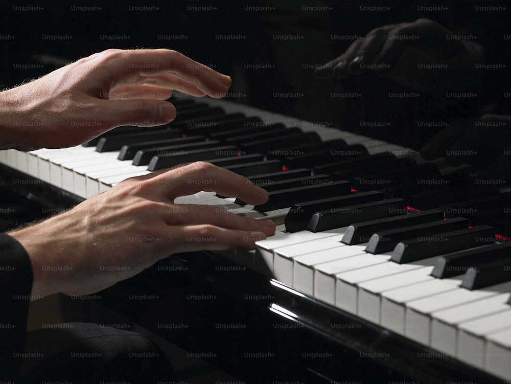 una persona tocando un piano con las manos