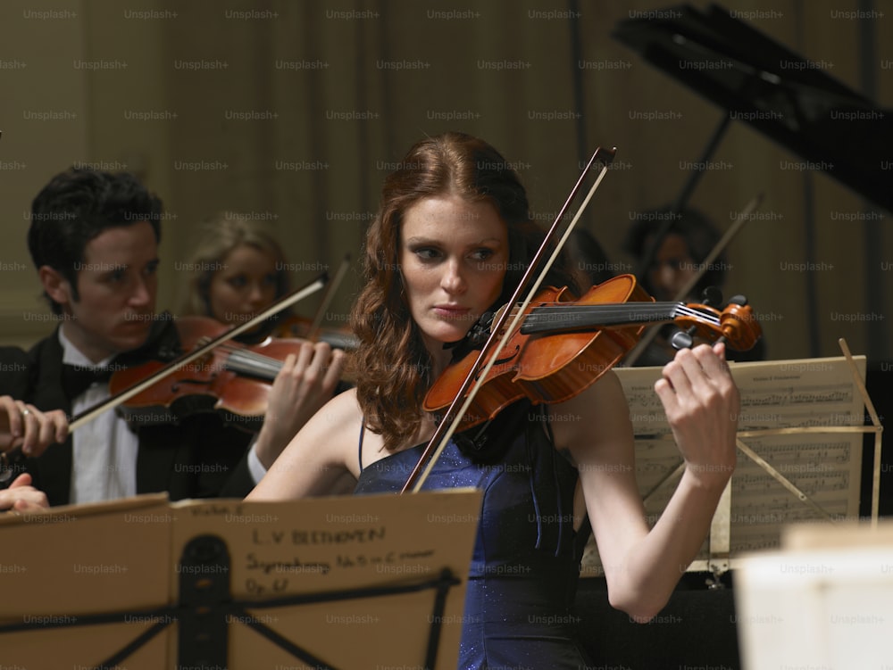 a woman in a blue dress playing a violin