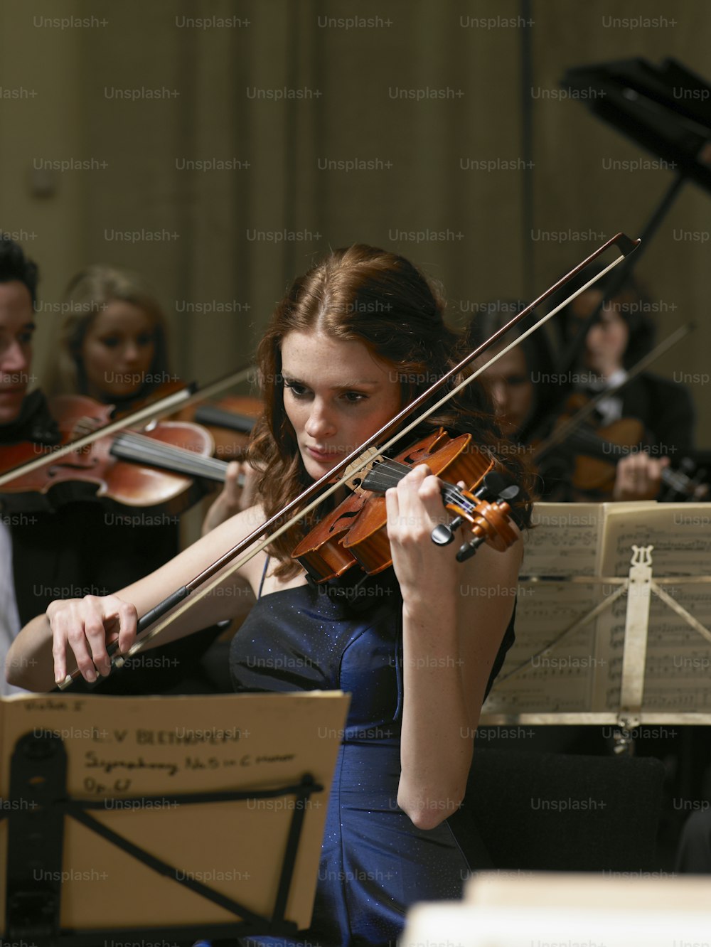 a woman in a blue dress playing a violin