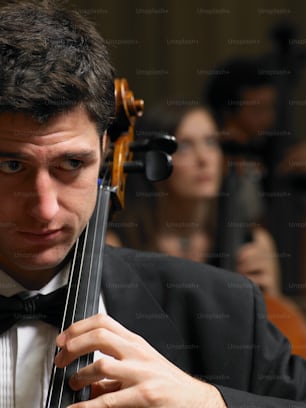 a man in a tuxedo holding a violin