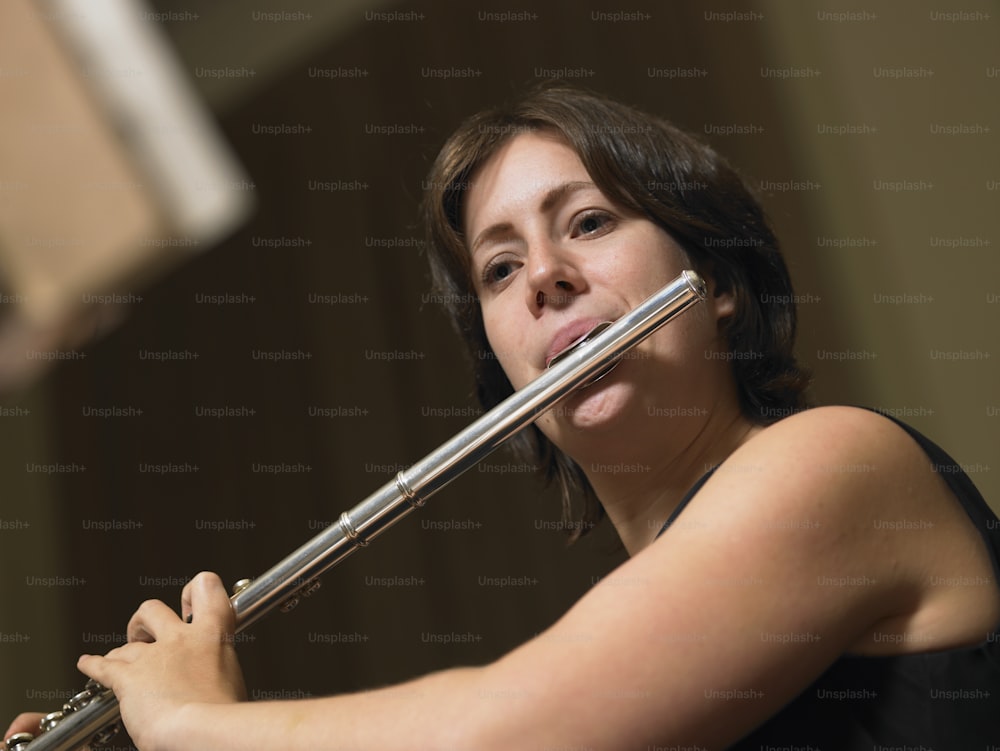 uma mulher tocando flauta em um quarto