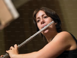 a woman playing a flute in a room