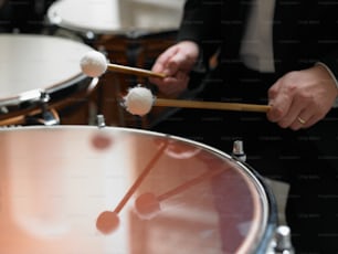 a man in a suit playing a drum set