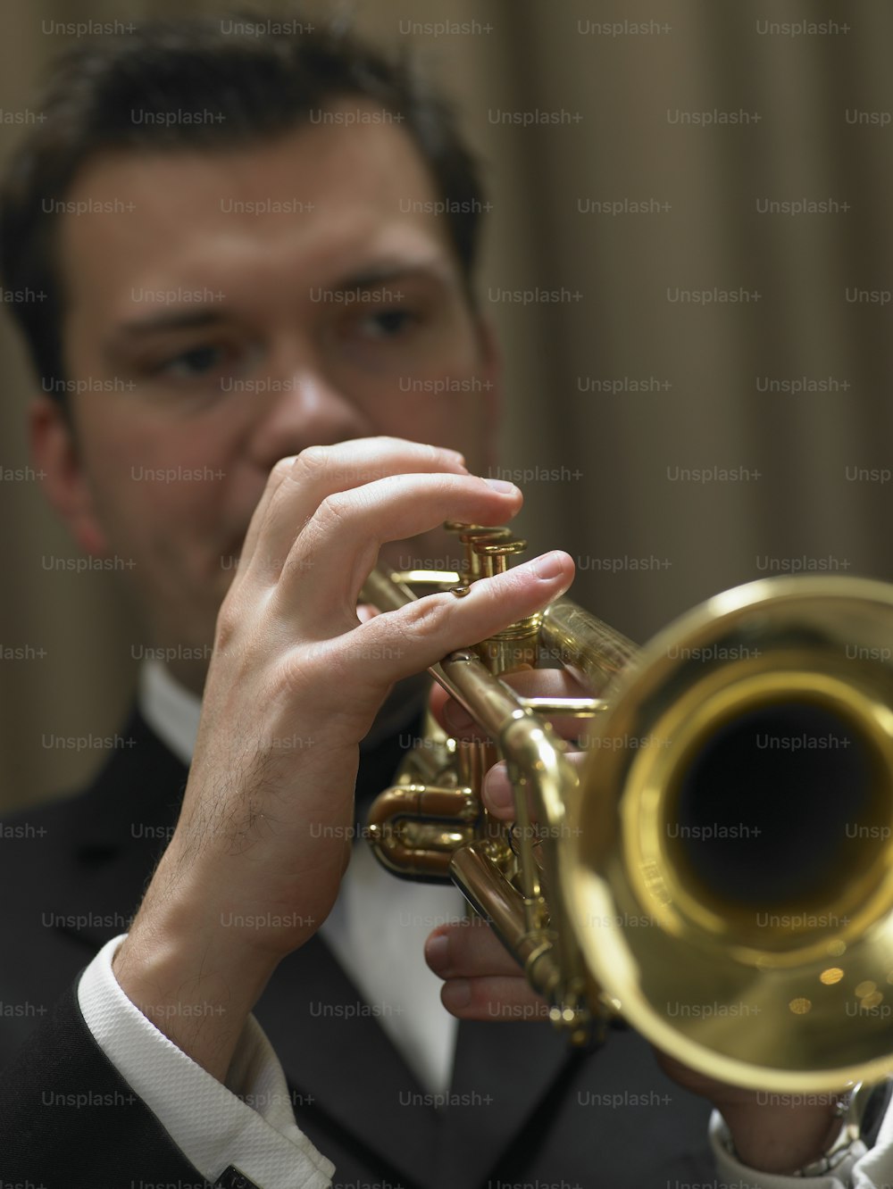Un hombre con esmoquin tocando una trompeta