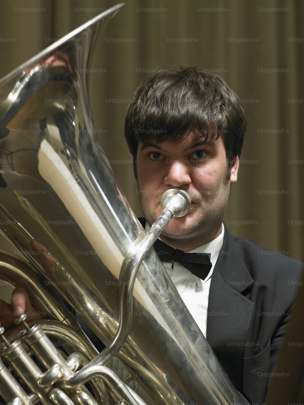Un hombre con esmoquin tocando una trompeta