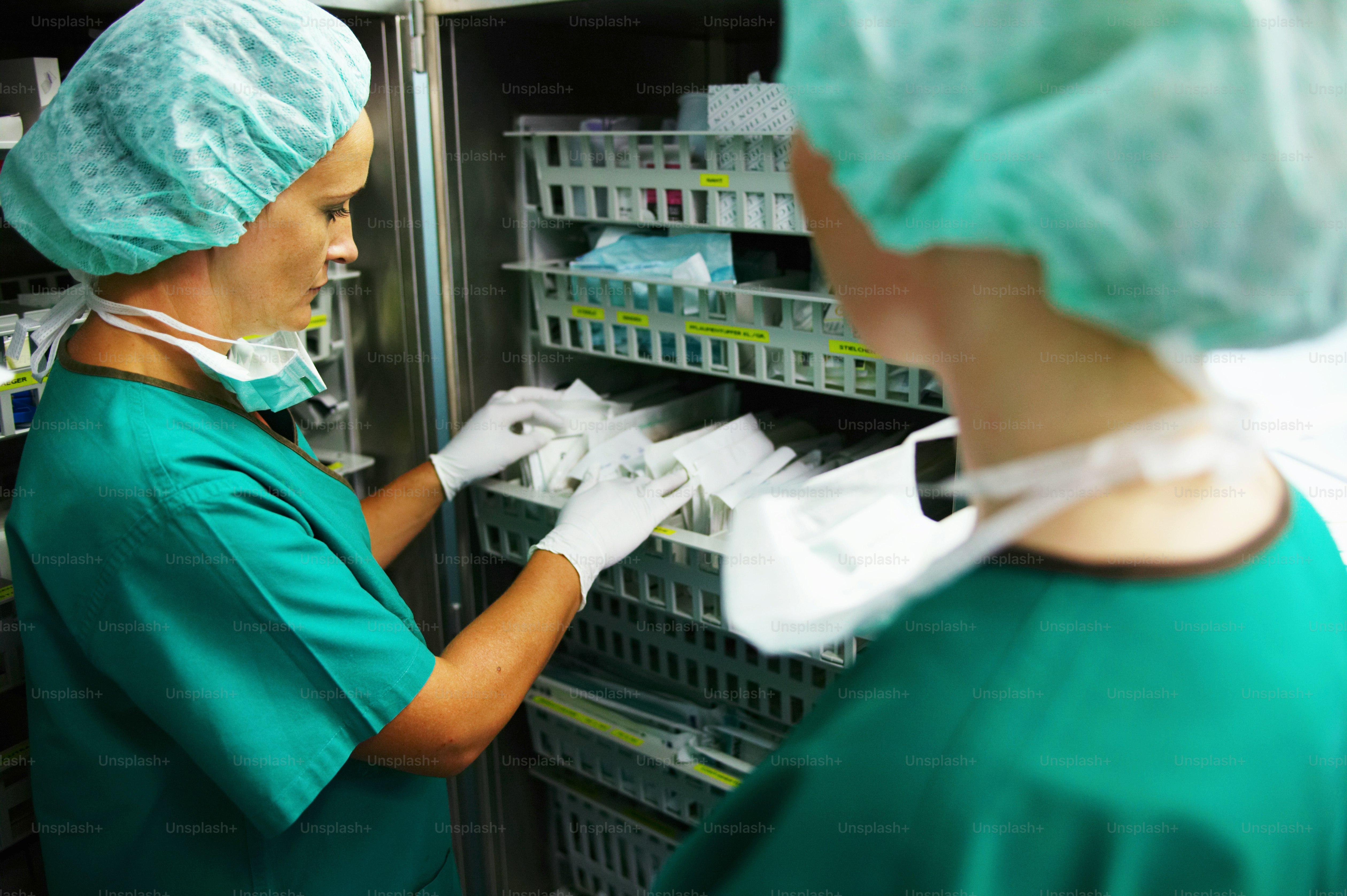 Healthcare staff reviewing RFID cabinets for medical supply tracking inside a hospital inventory room