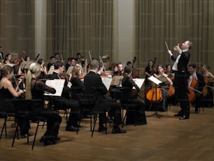 un direttore e un'orchestra in una grande sala