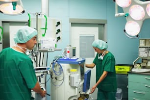 a couple of doctors standing around a hospital room