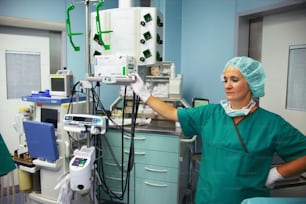 a woman in scrubs is operating a machine