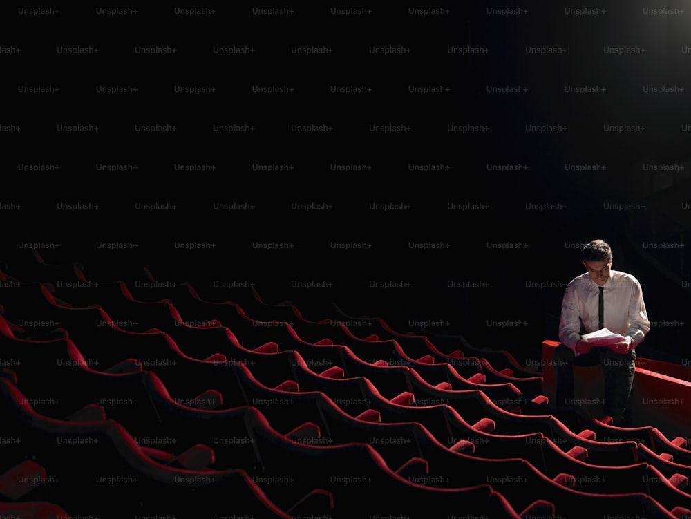 Ein Mann mit Krawatte, der in einem Theater sitzt