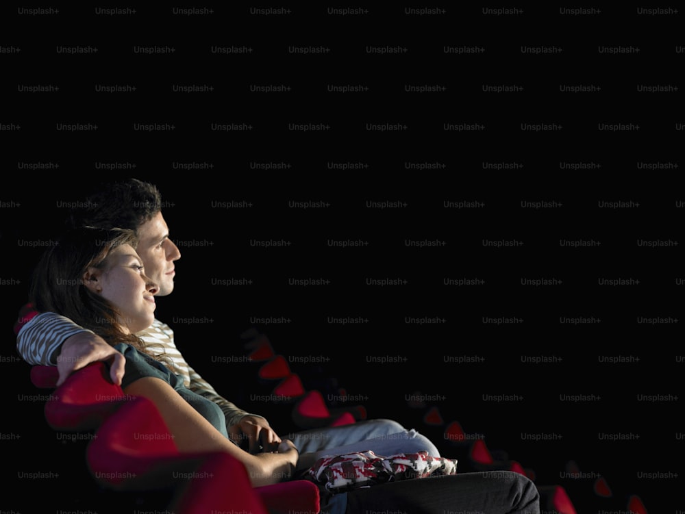 a couple of people sitting in a theater