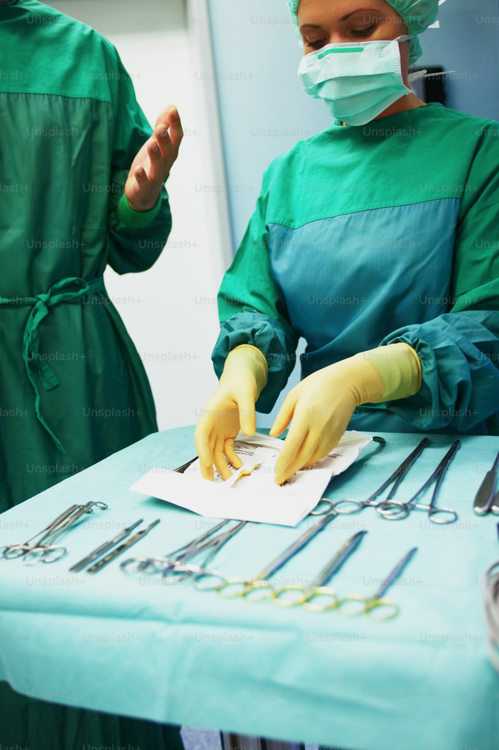 two surgeons in green scrubs and surgical equipment