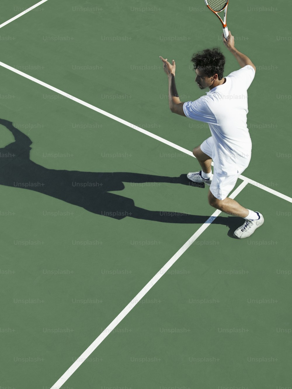 テニスコートでテニスラケットを持つ男性