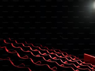 uma fileira de assentos vermelhos em um auditório escuro