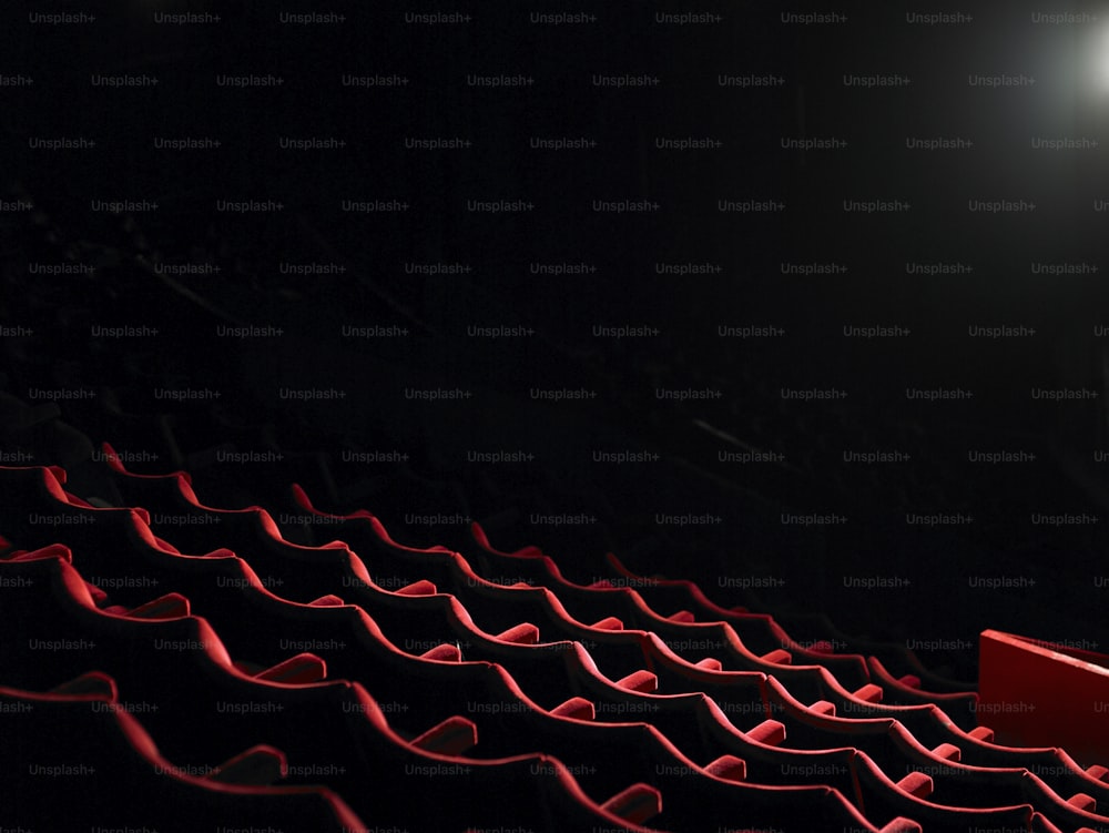 a row of red seats in a dark auditorium