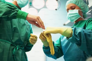 two surgeons in scrubs hold bananas in their hands