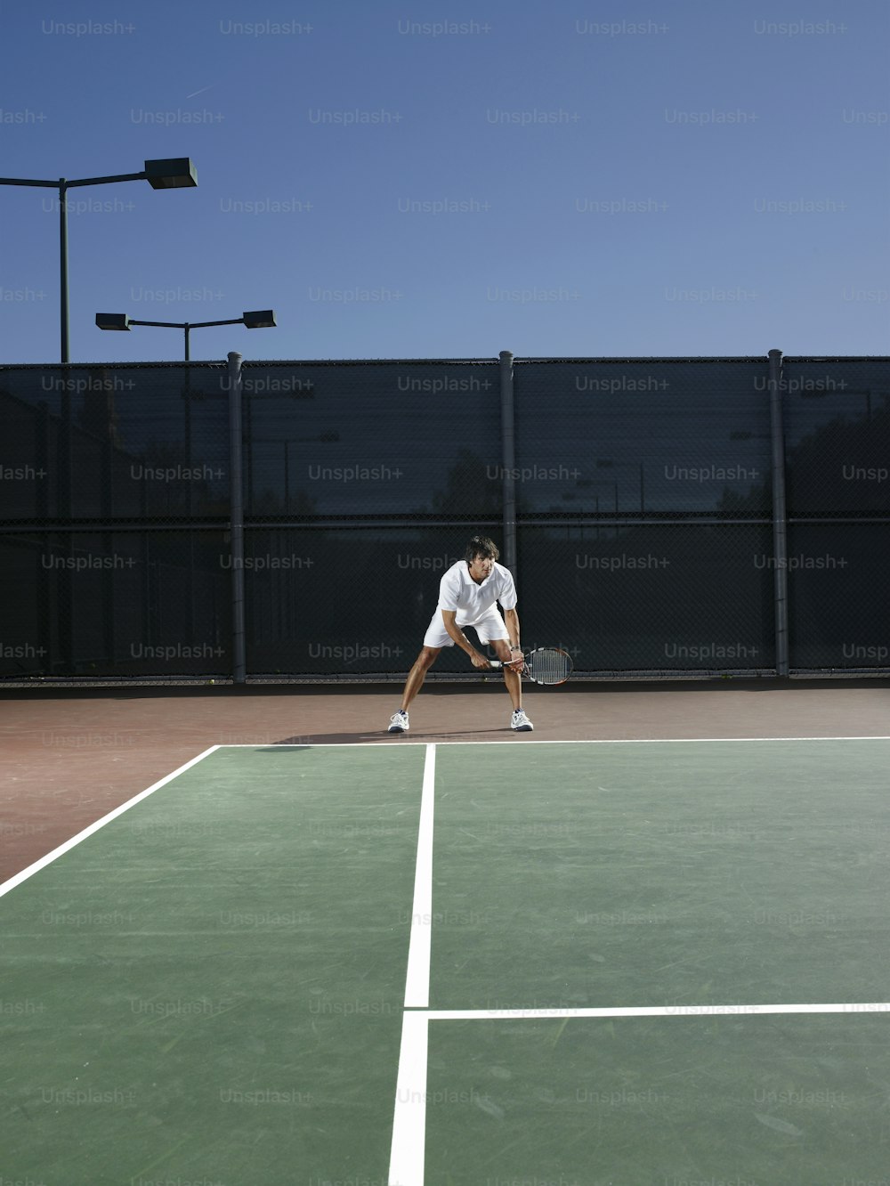 Ein Mann, der auf einem Tennisplatz steht und einen Schläger hält