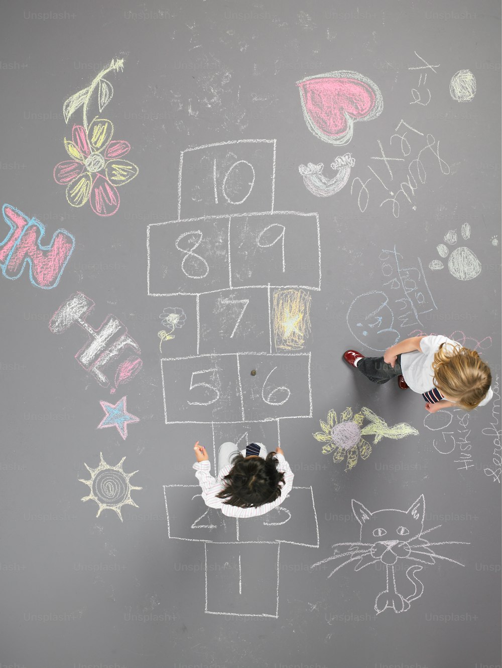 a little girl standing in front of a chalk board