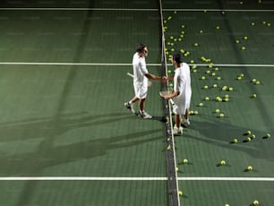 two tennis players shaking hands over a racket