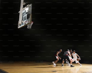 a group of young men playing a game of basketball