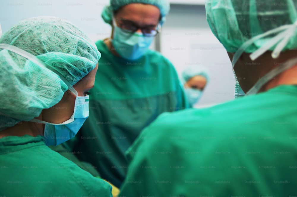 a group of surgeons in green scrubs and masks