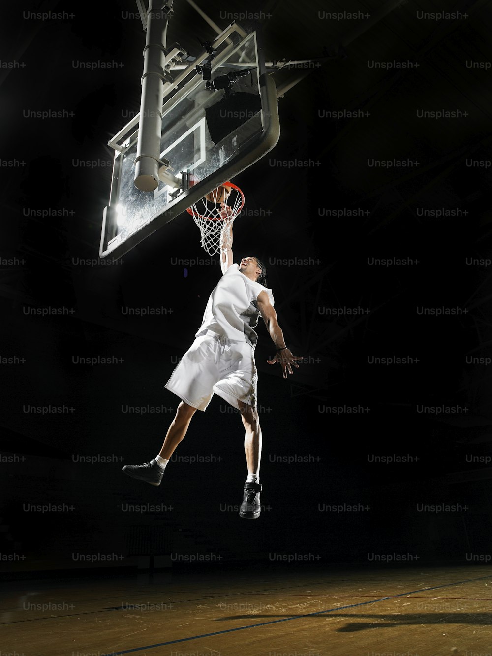 um jogador de basquete pulando no ar para enterrar uma bola de basquete