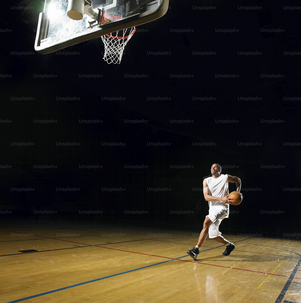 Um homem de camisa branca está jogando basquete