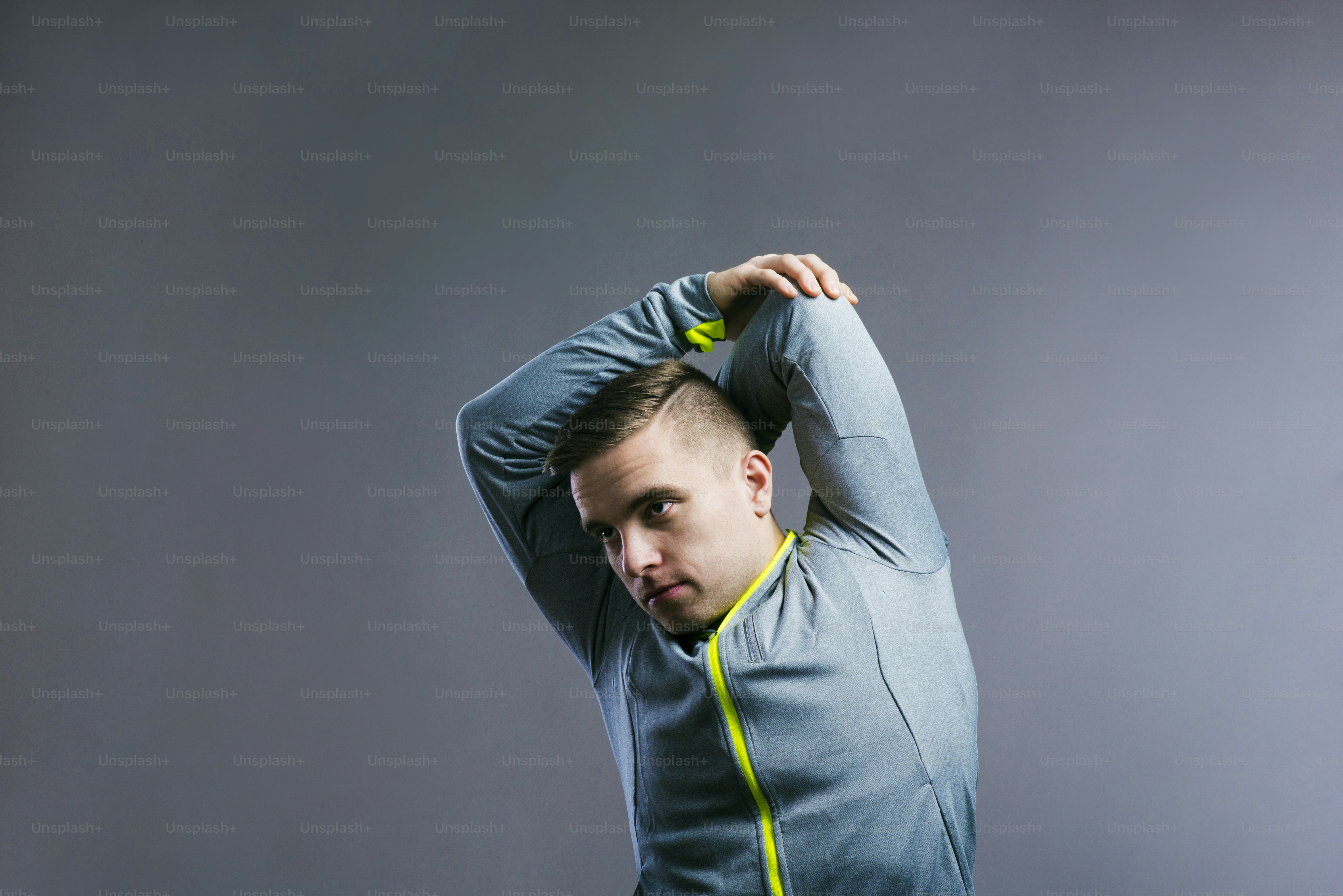 Handsome young runner. Studio shot on gray background.
