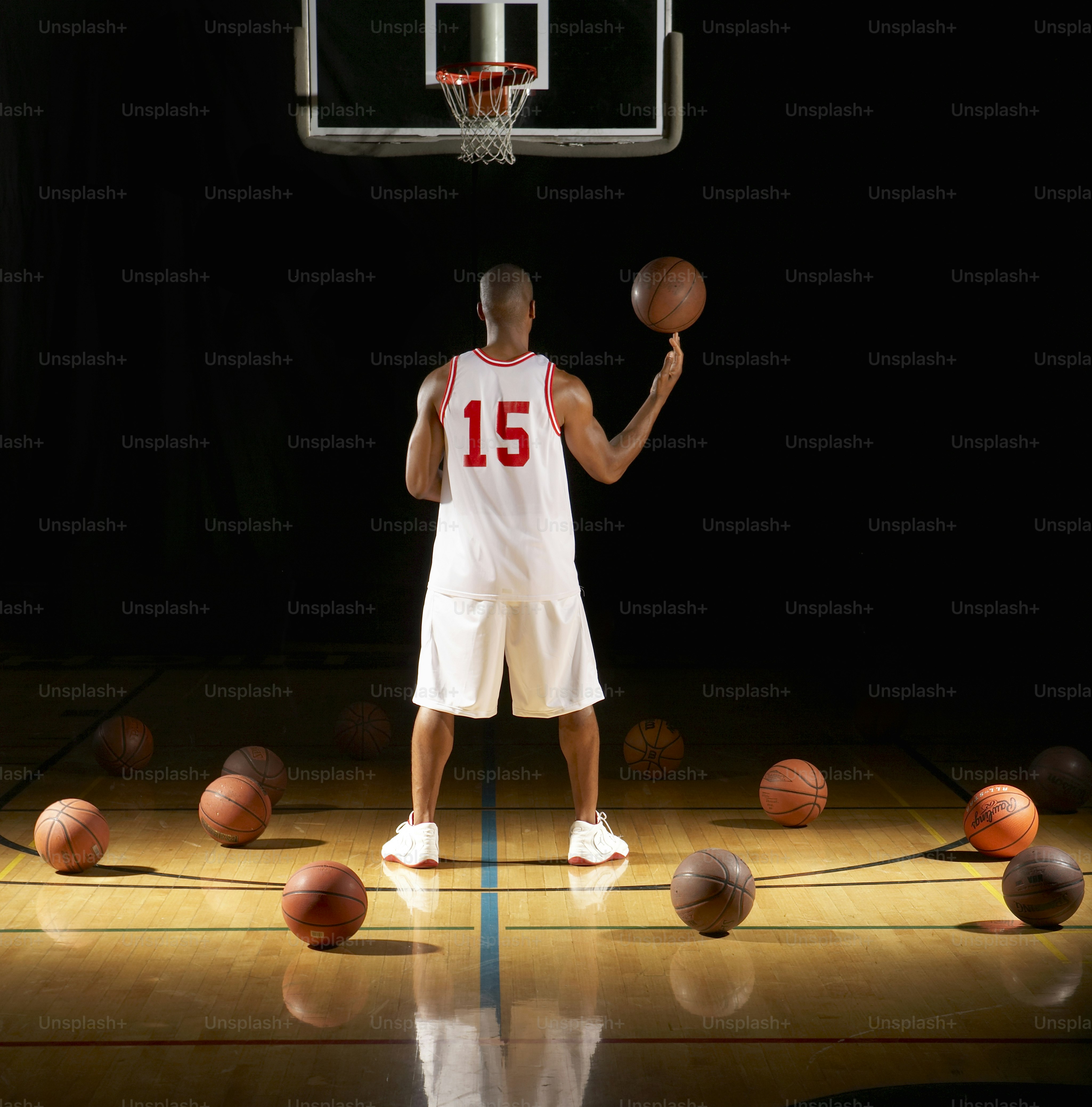 a man holding a basketball on top of a basketball court