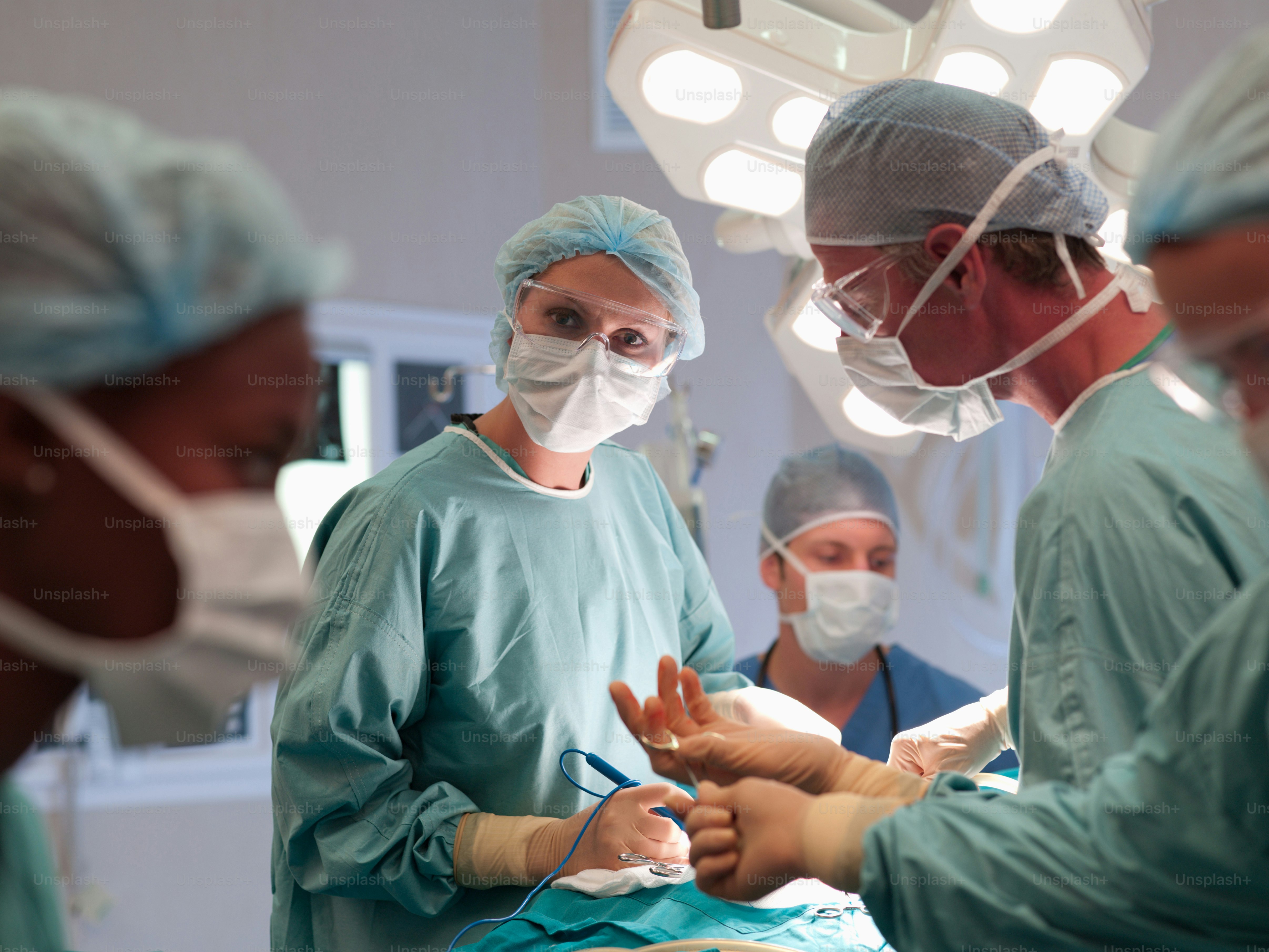 A group of doctors performing surgery in an operating room photo ...