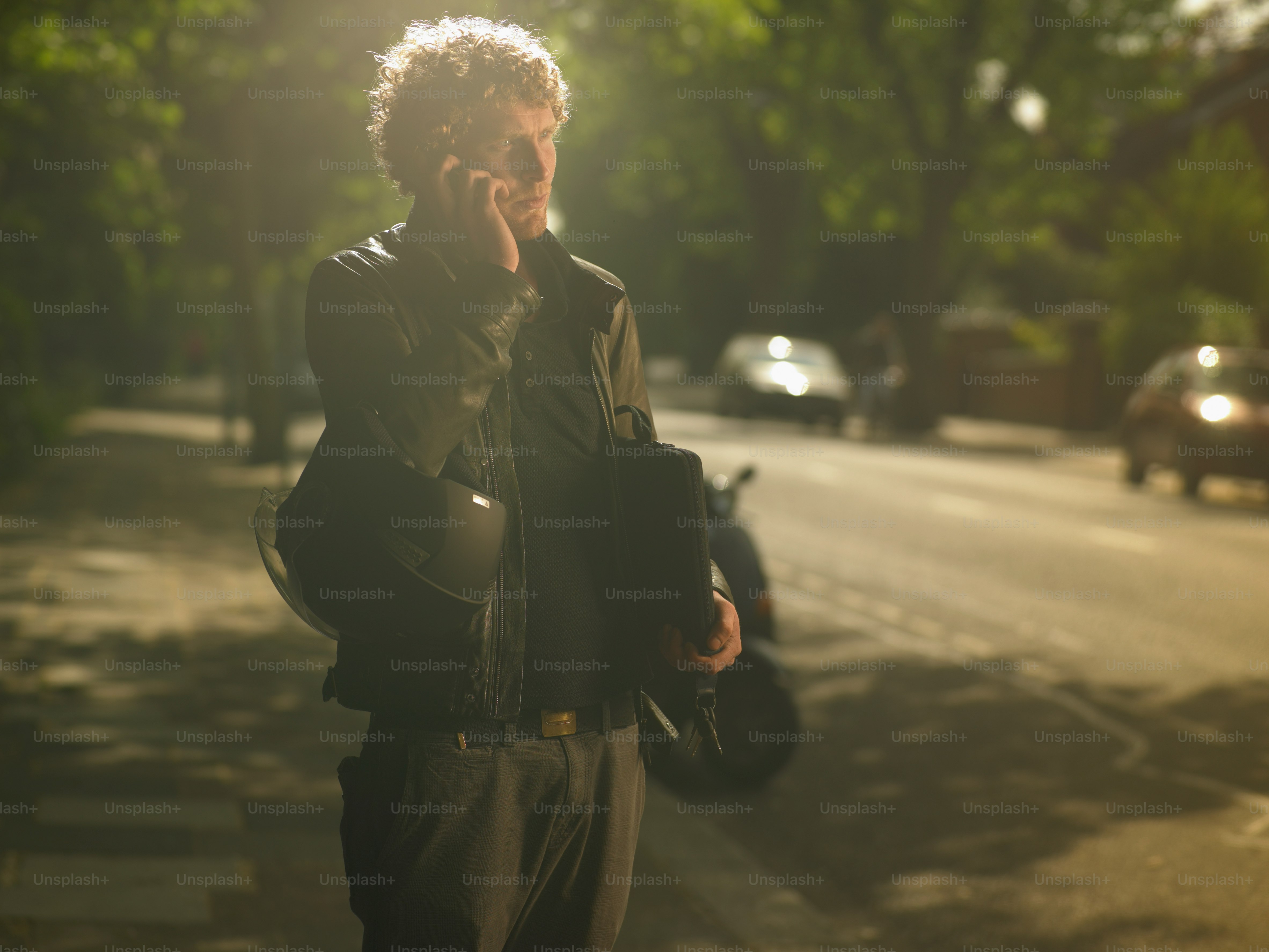a man talking on a cell phone while walking down a street