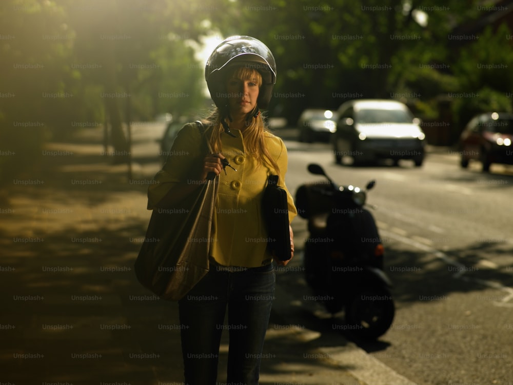 a woman wearing a helmet is walking down the street