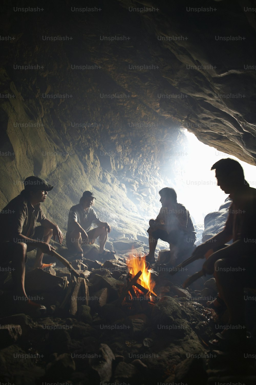 Un grupo de personas sentadas alrededor de un fuego en una cueva