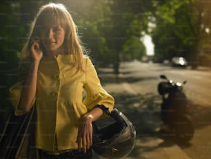 Eine Frau in einem gelben Hemd, die mit einem Handy spricht