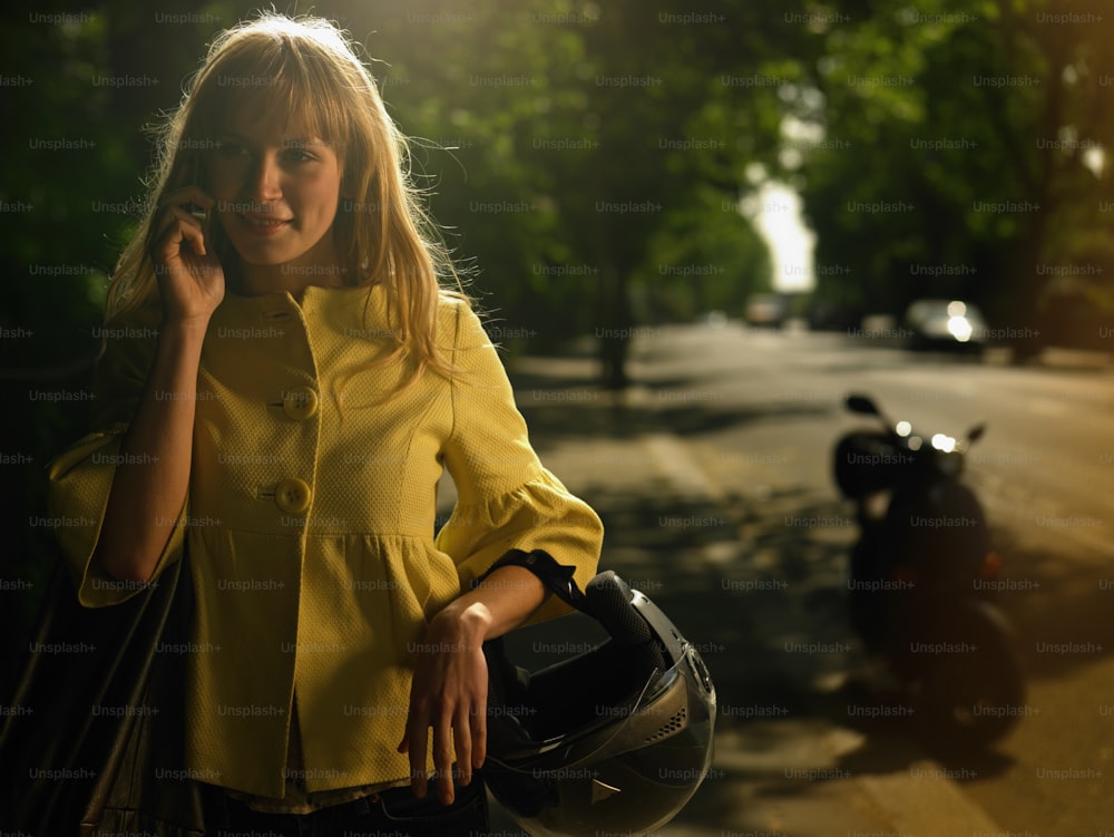 a woman in a yellow shirt talking on a cell phone
