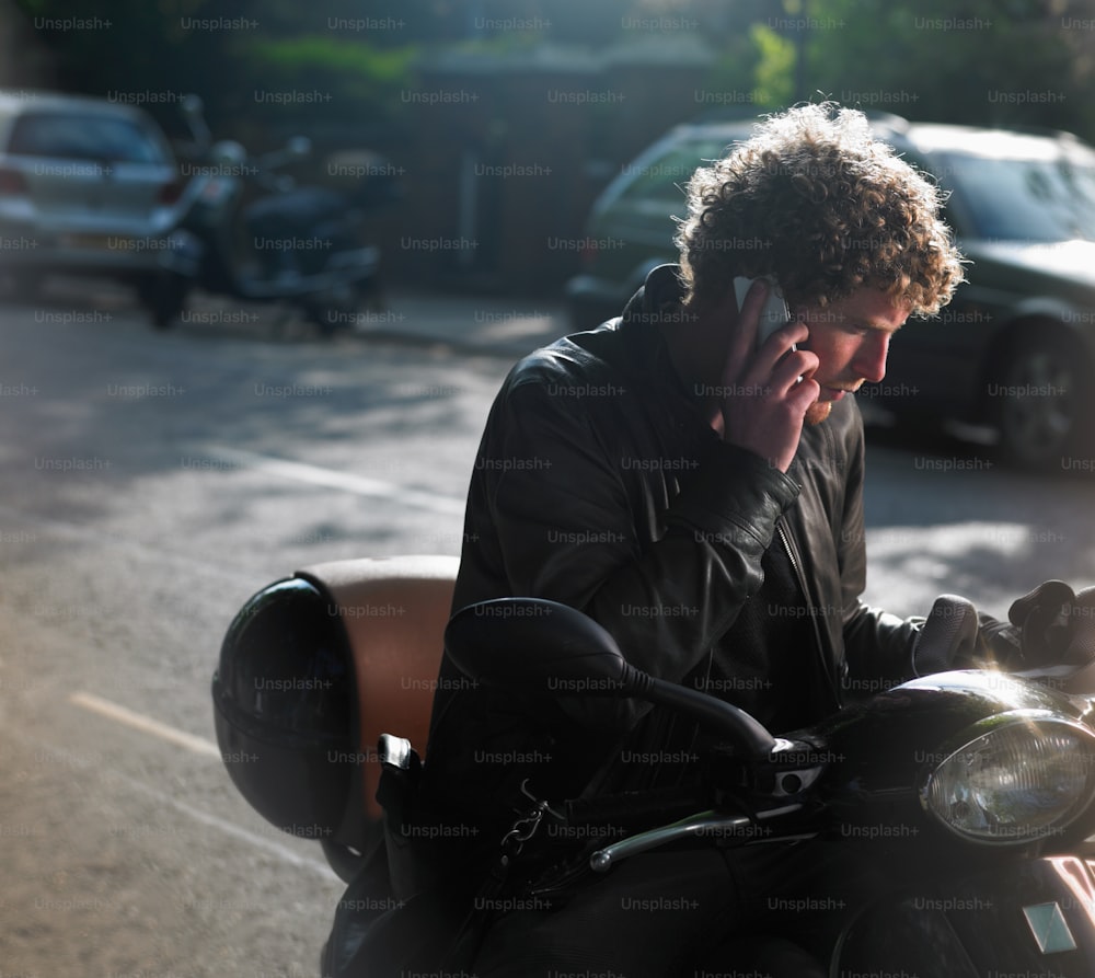 a man on a motorcycle talking on a cell phone