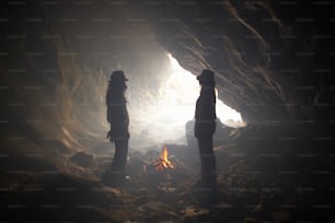 동굴에서 불 앞에 서 있는 두 사람