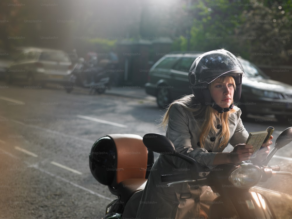a woman riding a motorcycle down a street