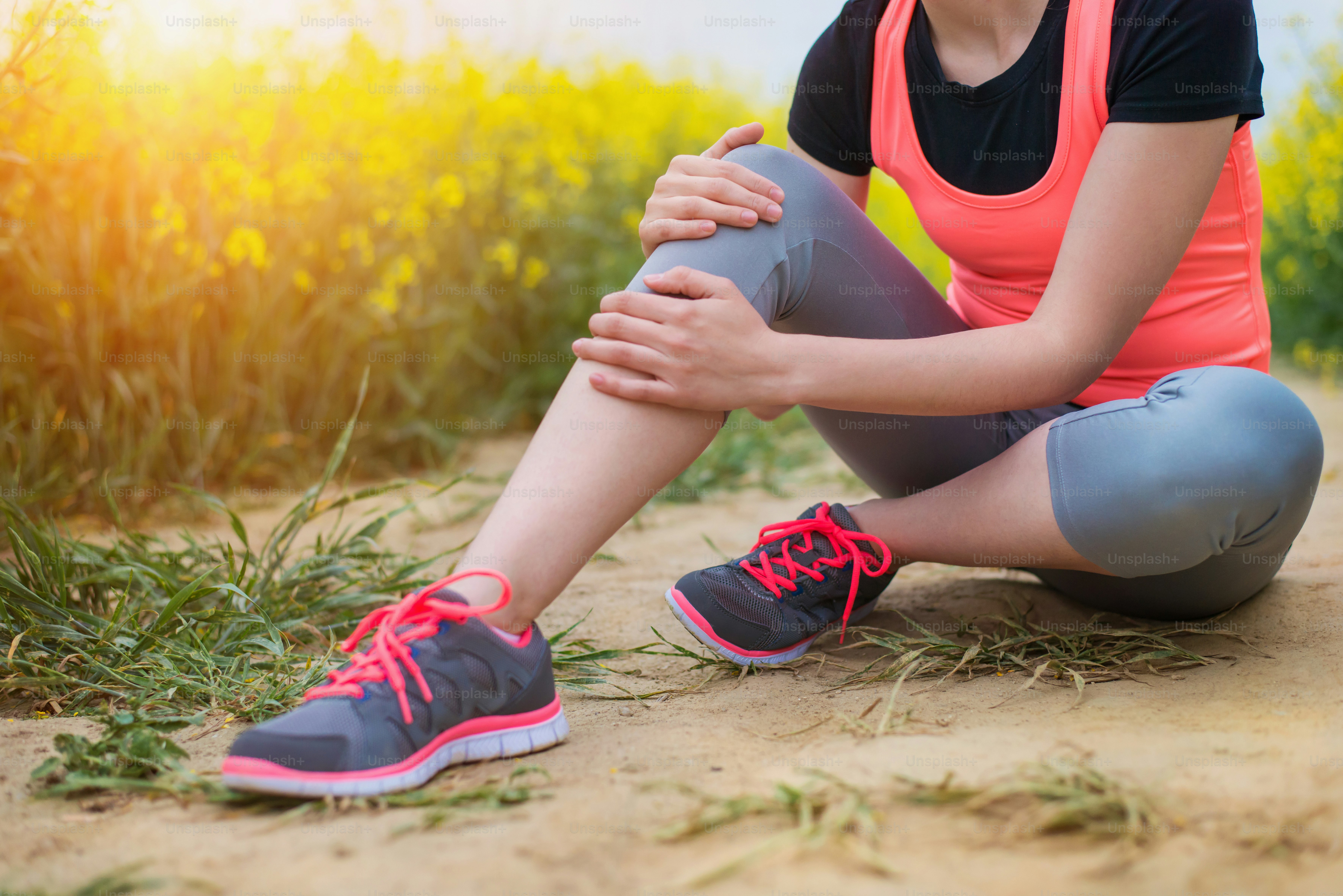 Young runner having an accident outside in spring canola field