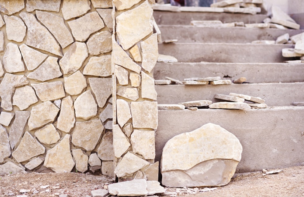 Installazione di una superficie decorativa in pietra naturale su una parete e scale