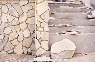 Installation einer dekorativen Natursteinoberfläche an einer Wand und Treppe