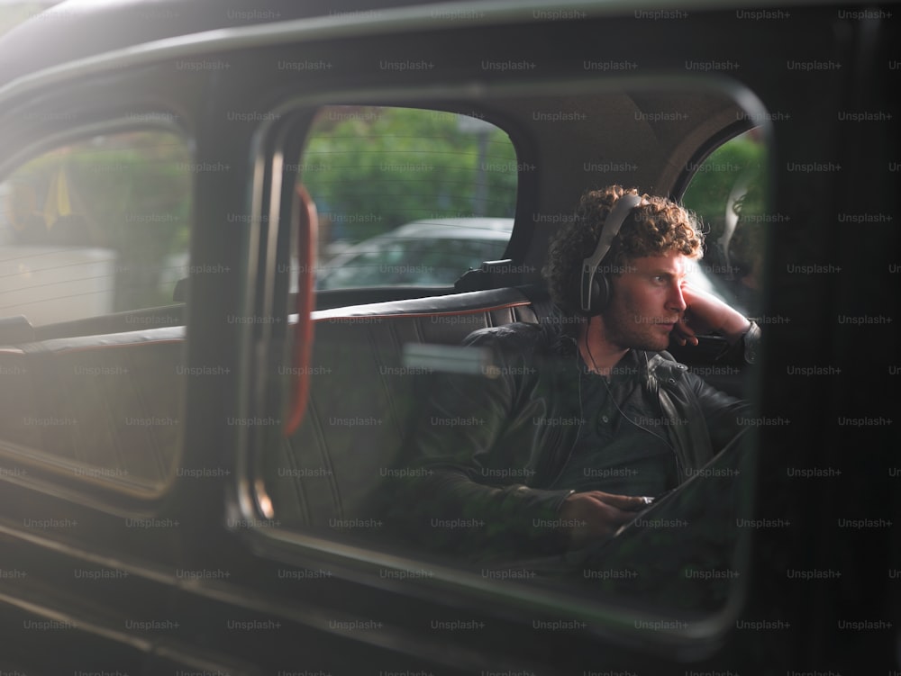 Un homme assis dans une voiture avec des écouteurs